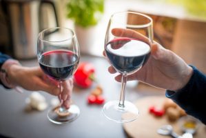 close-up-photo-of-two-people-toasting-with-red-wine-2101186